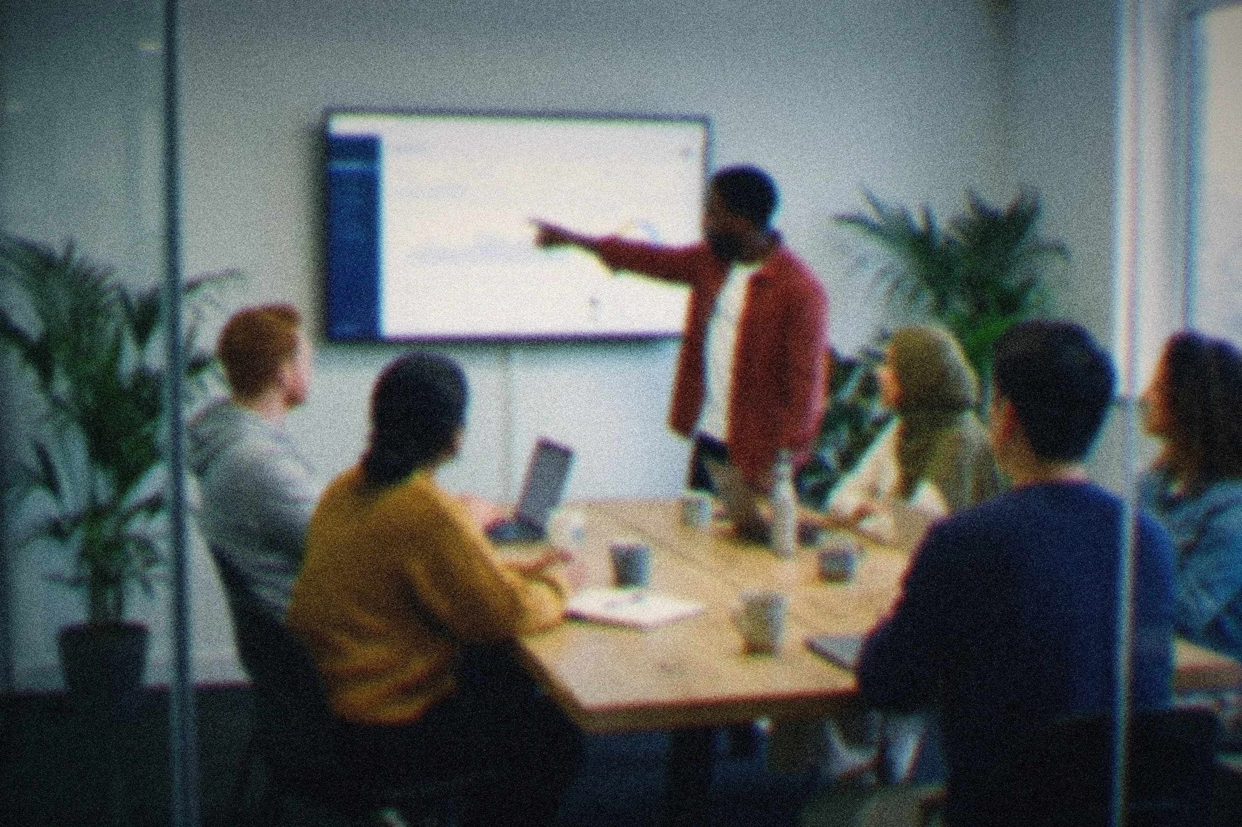 A team mapping how its work flows, one colleague walking the others through it on the wall screen