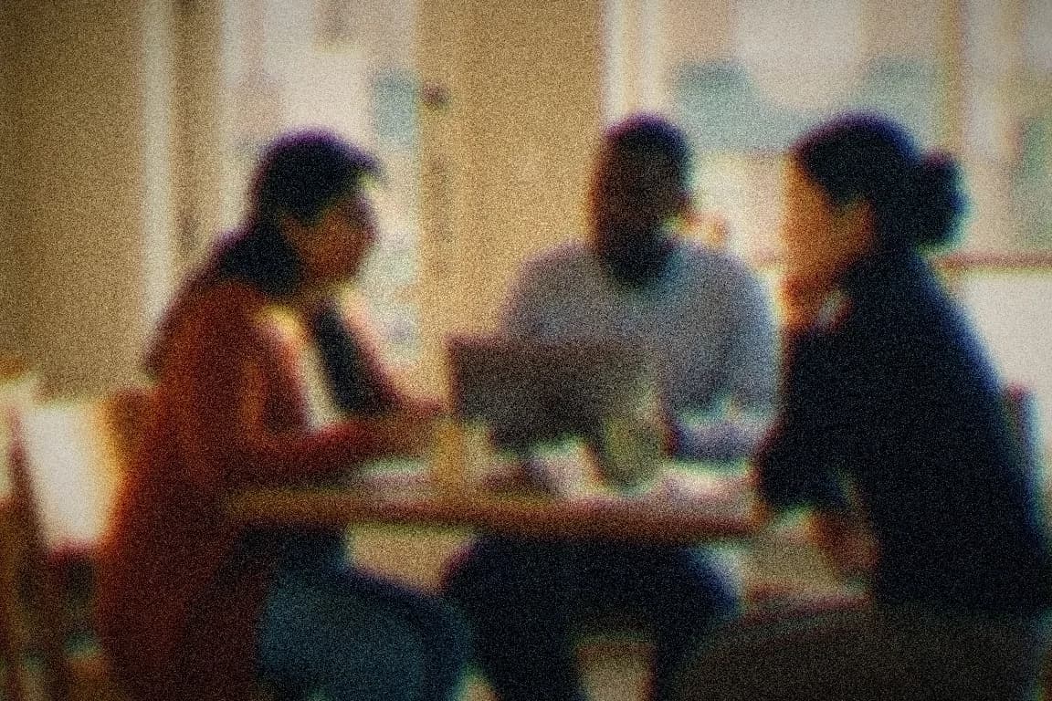 A laptop open at a café table, the day's work blurred quietly into everyday life.