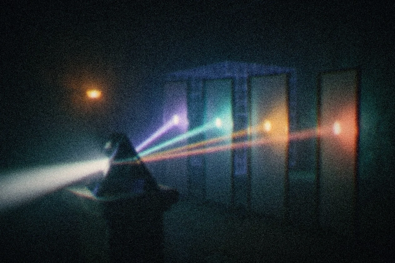 A single beam of light split by a dark prism into separate beams, each passing into its own frosted glass pane.